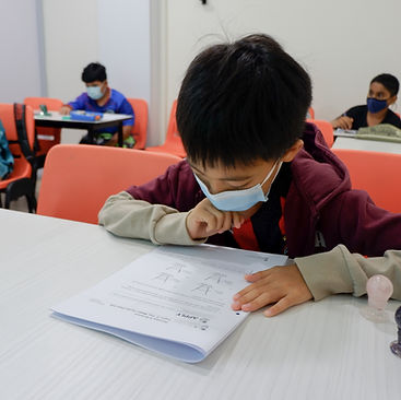 Students attending an online tuition class in Singapore with a tutor guiding them virtually.